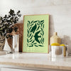 Abstract representation of yoga poses in green and gray hues - styled on a counter with eucalyptus and a bowl of lemons