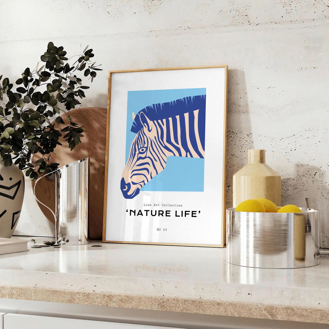 A stylized zebra in shades of blue and gray against a textured background - styled on a counter with eucalyptus and a bowl of lemons