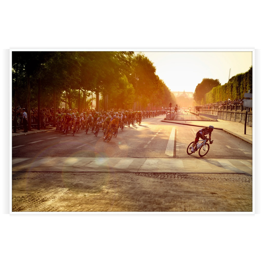 Dynamic cycling scene with cyclists racing through a green landscape under an orange sky - in a white frame